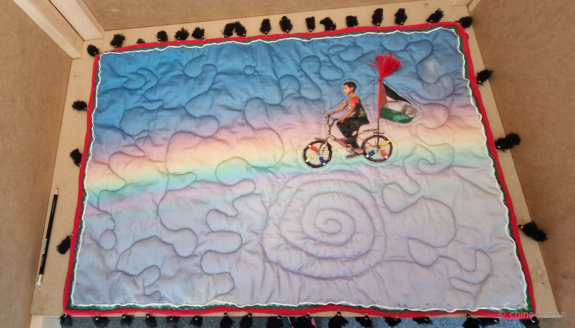 Dream — quilt of a child riding a bicycle with a Palestinian flag