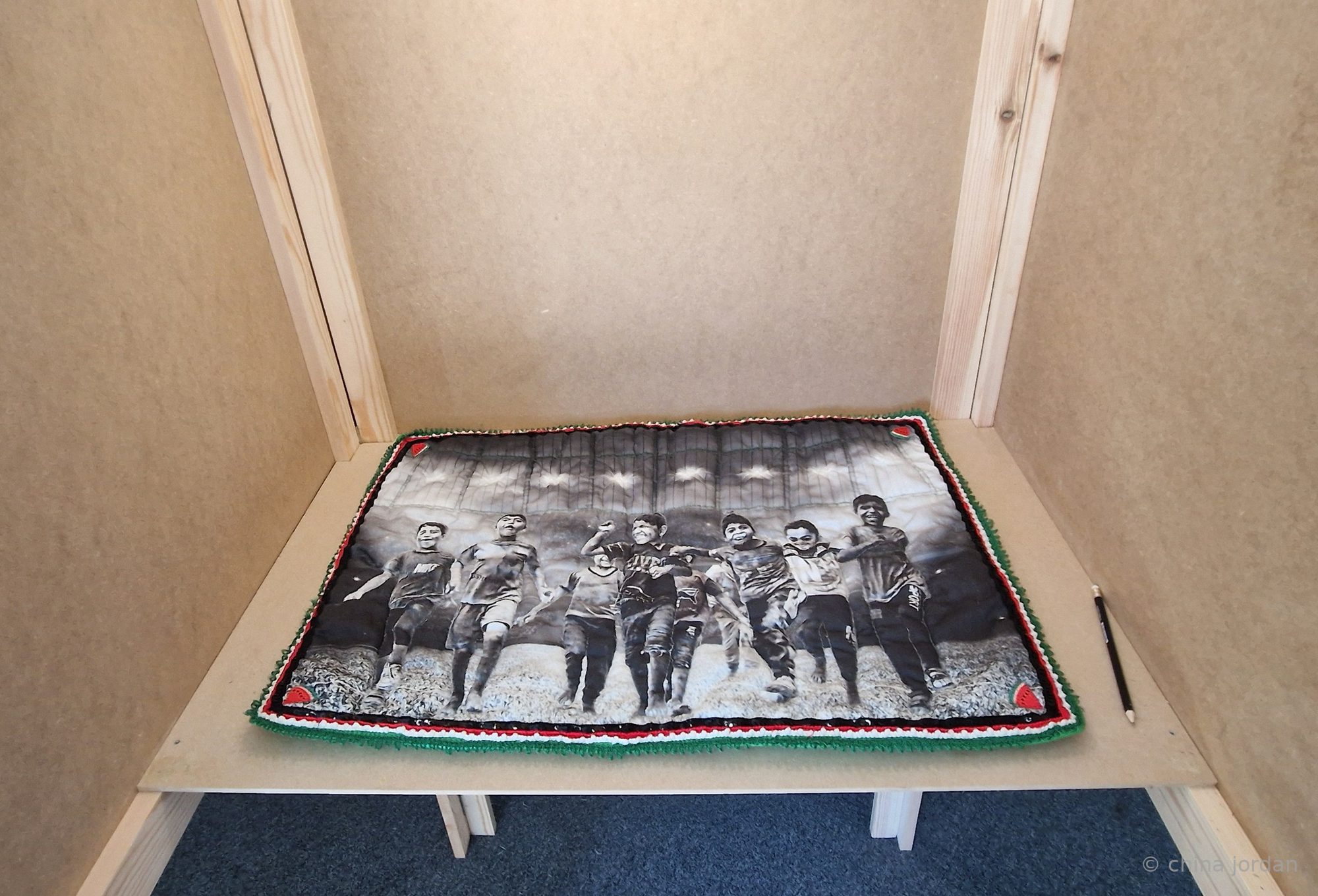 Play — black and white quilt of boys running, installed in the sculpture